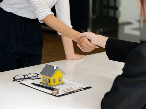 Real estate broker and customer shaking hands after signing a contract: real estate, home loan and